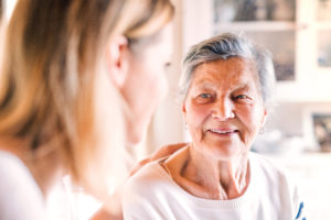 An elderly grandmother with an adult granddaughter at home.